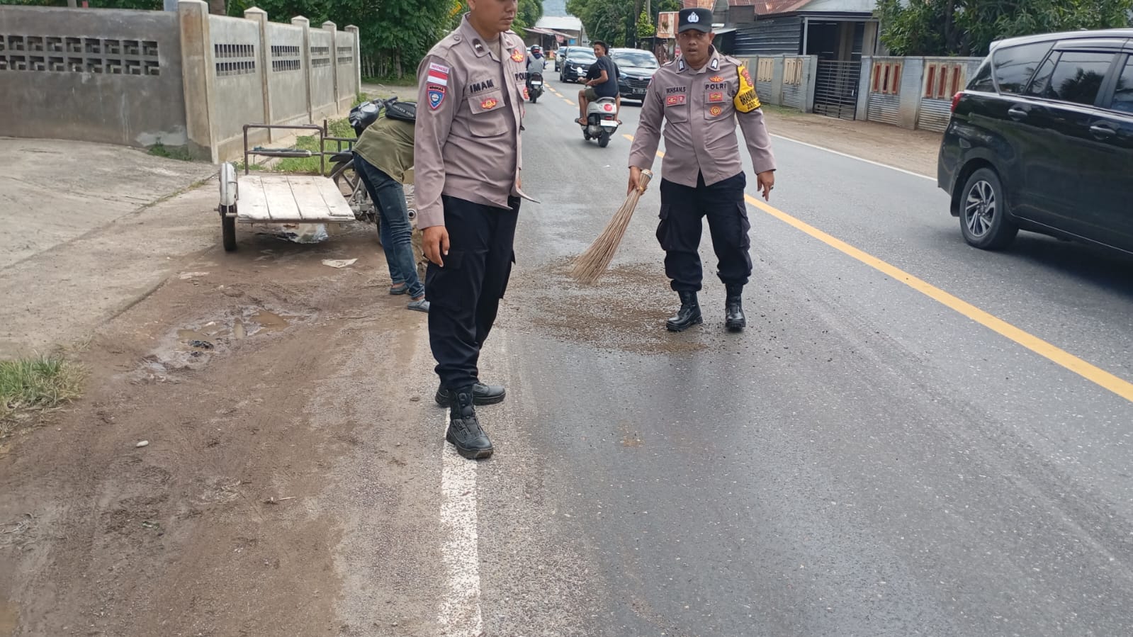 Cegah Pengendara Terjatuh, Polsek Lhoknga Tabur Pasir di Jalan Licin Akibat Tumpahan Oli
